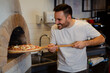 © zorandim75 - A process of preparing pizza by a chef.Italian traditional pizza is cooked in a stone wood-fired oven.