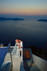 Wall Mural - Beautiful young couple bride and groom posing on Santorini island, Greece