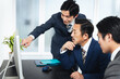 © metamorworks - パソコン画面を見ながら会議するビジネスマンのグループ