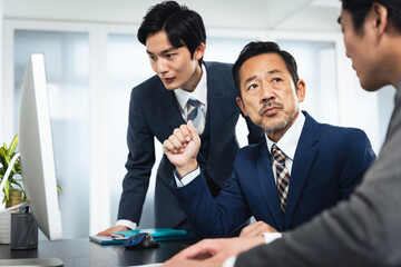 Leinwandbilder - パソコン画面を見ながら会議するビジネスマンのグループ