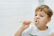 © Yulia Raneva - cute 5 years old boy brushing teeth with bamboo tooth brush in bathroom. Image with selective focus