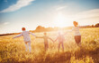 © candy1812 - Family by holding hands running on the sunset on the field.