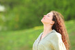 © PheelingsMedia - Woman breathing fresh air in green