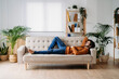 © Westend61 - Young man relaxing on sofa at home