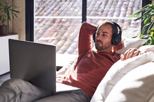 Man Wearing Headphones Watching Movie On Laptop At Home