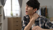 © PRPicturesProduction - asian Japanese male student is pounding massaging his stiff shoulders and groaning with grimacing face after studying for a long time while learning from home
