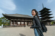 © PR Image Factory - portrait of attractive asian Taiwanese girl turning to smile at camera with gojunoto pagoda of kofuku-ji temple at background on bright sunny day in nara japan