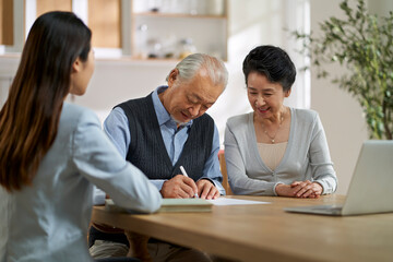 Wall Mural - senior asian couple signing a contract at home