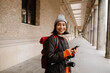 © Drobot Dean - Smiling asian woman tourist using smartphone during walk through the old city street