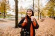 Beautiful smiling asian woman drinking takeaway coffee during walk in park