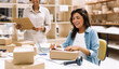 © (JLco) Julia Amaral - Happy female entrepreneur preparing an online order for shipping