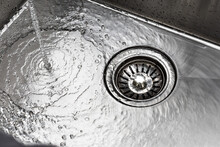 Water Drains Down A Stainless Steel Sink