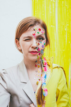Woman With Stickers On Face Winking In Front Of Two Tone Wall