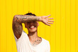 © VISTA by Westend61 - Happy man covering eyes with hand in front of yellow wall