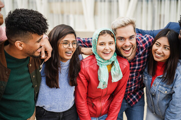 Wall Mural - Young diverse people having fun outdoor laughing together - Soft focus on arabian girl face