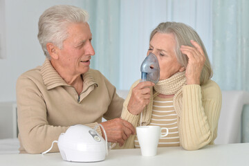 Poster - Portrait of sick old woman with inhaler and man at home