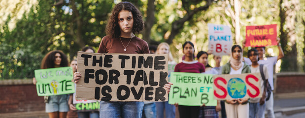 Wall Mural - Young girl leading a march against climate change