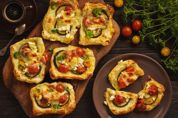 Wall Mural - Crispy puff pastry mini tarts with zucchini, tomatoes and cheese. 