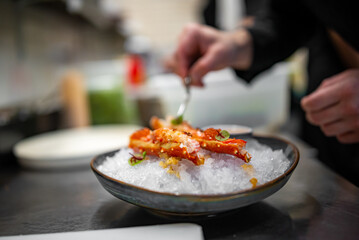 chef cooking crab legs with caviar on kitchen