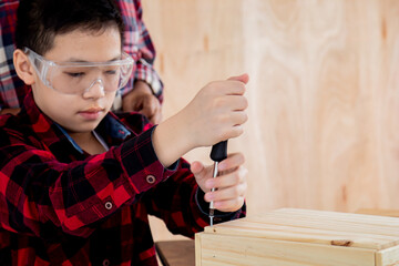 Wall Mural - Close up lovely Asian carpenter boy practice skill of screw knot on woodworking table carpentry shop