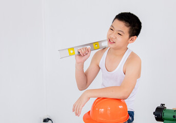 Wall Mural - Lovely Asian carpenter boy acting present his work in front of DIY woodworking table carpentry shop with copy space