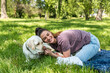 Young woman adopt young dog Labrador Retriever from animal rescue shelter center and gave him love and friendship. Female animal lover spending time with her puppy in the park.