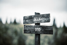 Vintage And Rustic Wooden Signpost With The Weathered Text Quote Seek God, Outdoors In Nature. Blurred Out Forest Fall Colors In The Background.
