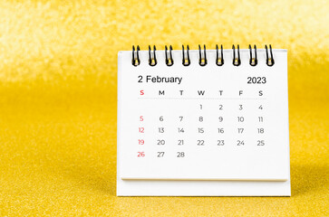 The February 2023 Monthly desk calendar for 2023 year on golden color background.