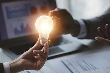 Businessman holds a glowing lamp, Creative new idea. Innovation, brainstorming, strategizing to make the business grow and be profitable. Concept execution, strategy planning and profit management.