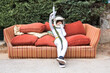 © ADDICTIVE STOCK - Child in space suit shooting gun on sofa on street