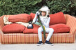 © ADDICTIVE STOCK - Boy in spacesuit having phone conversation on couch in park