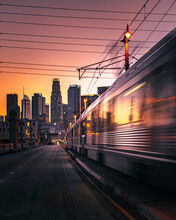 View Of A Train Crossing Downtown Los Angeles At Sunset, California, United States.