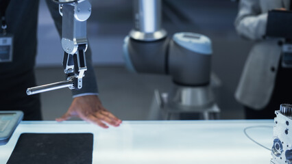Aufkleber - Close Up Shot of a Modern Robotic Arm Holding and Moving a Mechanical Metal Component. Diverse Team of Engineers Using Tablet Computer to Manipulate and Program the Robot.