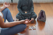 © ADDICTIVE STOCK - Crop woman meditating near Buddha statue at home