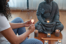 Crop Female Buddhist Lightning Candle During Prayers To Buddha