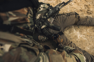 Wall Mural - Wounded man lying on a ground, other soldiesr next to him