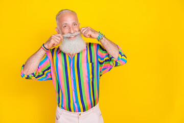 Wall Mural - Portrait of satisfied glad funny old man long beard wear colorful shirt fingers touching mustache isolated on yellow color background