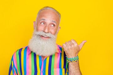 Sticker - Portrait of funny cheerful old man with long beard wear colorful shirt directing look empty space isolated on yellow color background