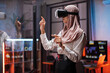 © sofiko14 - Young female company workers wearing VR headset while having meeting at office room. Confident muslim woman in hijab using innovative technology during business strategy.