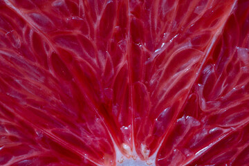 Wall Mural - Closeup of sliced ripe grapefruit, macro. Red fresh grapefruit surface background or texture. Top view