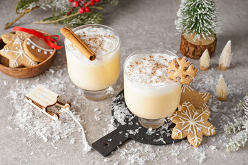 Wall Mural - Glasses of tasty eggnog cocktail, Christmas decorations and cookies on grunge background