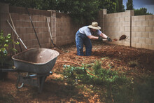 Man Digging Soil In Backyard