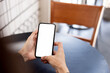 © panitan - cell phone blank white screen mockup.hand holding texting using mobile on desk at office.background empty space for advertise.work people contact marketing business,technology