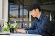 © bongkarn - Professional Asian businessman using laptop, typing on notebook keyboard at his office desk.