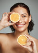 © K Abrahams/peopleimages.com - Woman, smile and orange in studio for skincare, health and wellness with cosmetic glow, self care and backdrop. Model, black woman and fruit for cosmetics, detox or healthy natural skin by background