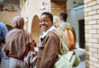 © S Fanti/peopleimages.com - Black woman, happy or portrait on university, school or college campus with friends, people or global study group. Smile, face or diversity students walking to education class or learning buildings