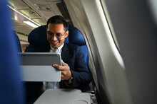 Smiling Businessman Passenger Checking News Digital Tablet, Using Wireless Connection On Board During Flight