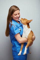 Wall Mural - Veterinarian doctor woman holding dog on hands.Isolated portrait of female medical worker with animal.