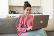 © deniskomarov - Pretty girl at her laptop sitting at home chatting via video communication