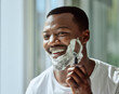 © S Fanti/peopleimages.com - Face, shaving and razor with a black man grooming in the bathroom mirror of his home for beauty or skincare. Beard, shave and blade with a handsome male in the morning for his hair removal routine